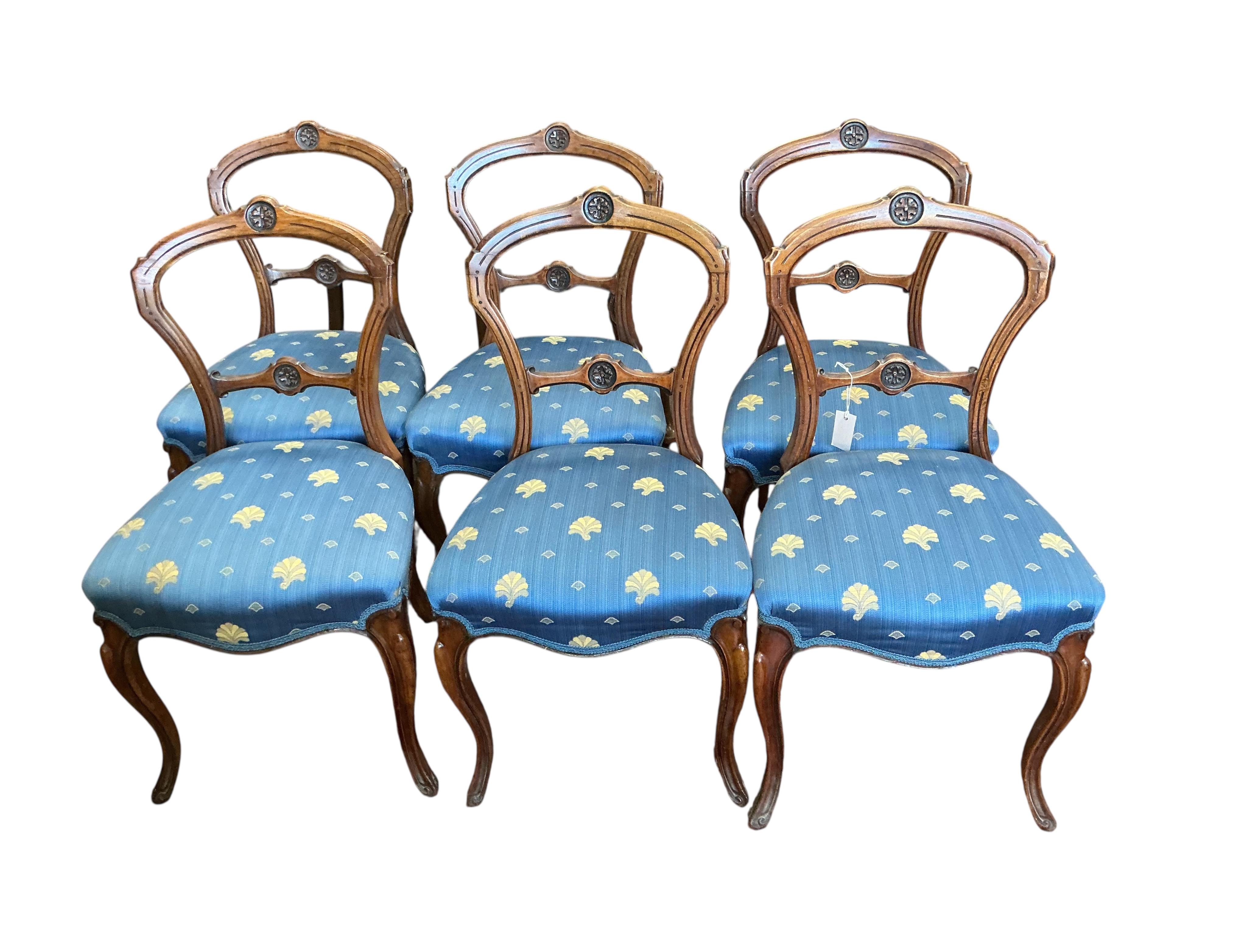 A set of six Victorian walnut balloon back dining chairs